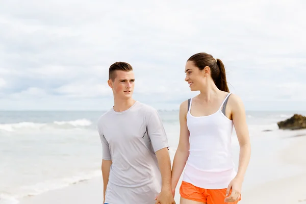 Des coureurs. Jeune couple courant sur la plage — Photo