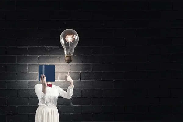 Mujer escondiendo la cara detrás del libro —  Fotos de Stock