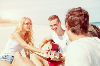 Sahilde gitar ile güzel gençler