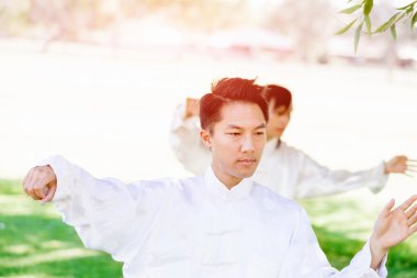 Yakışıklı adam Thai Chi yapıyor.