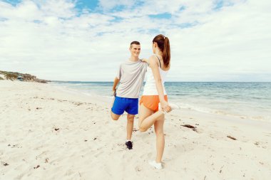 Kaçakçıları. Egzersiz ve stertching sahilde genç Çift