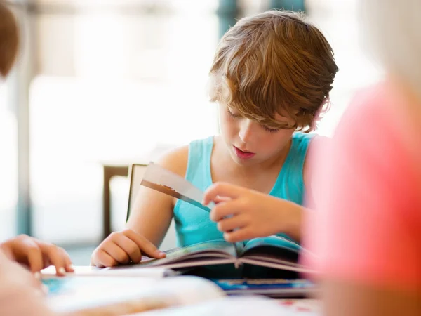 Junge in der Bibliothek — Stockfoto