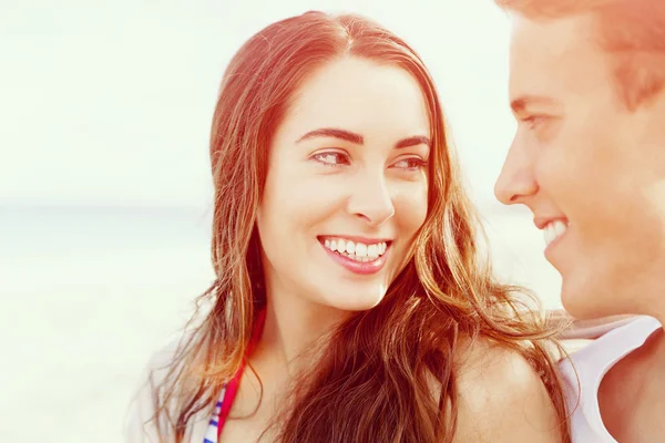 Romantische jonge paar zittend op het strand — Stockfoto