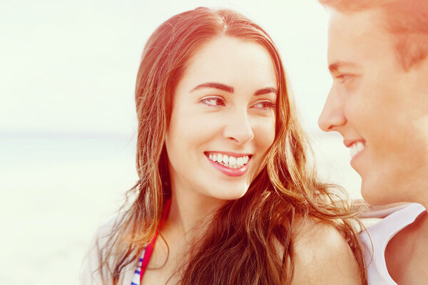 Романтическая молодая пара сидит на пляже
