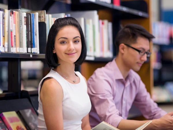 Két fiatal diák, a könyvtár — Stock Fotó