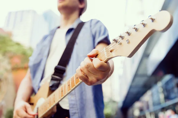 Jonge musicus met gitaar in stad — Stockfoto