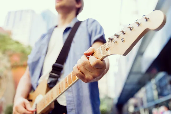 Młody muzyk z gitara w mieście — Zdjęcie stockowe