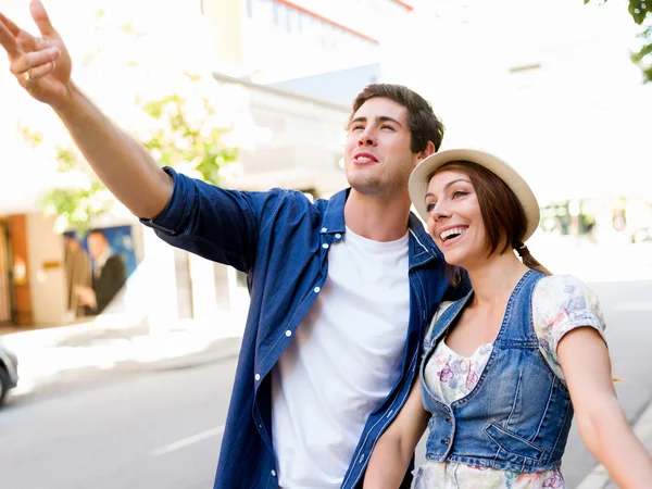 Happy young couple walking in city — Stock Photo, Image
