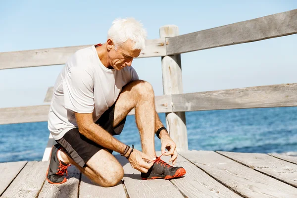 Löpare spetsar hans skor och förbereder att jogging — Stockfoto