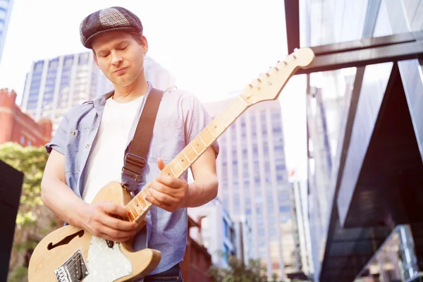 Jovem músico com guitarra na cidade — Fotografia de Stock