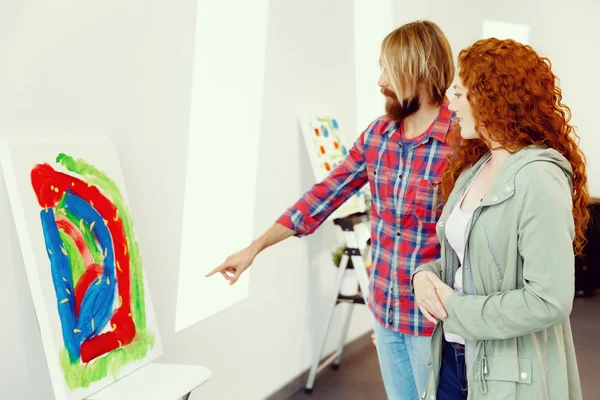 Jeune couple caucasien debout dans une galerie et contemplant des œuvres d'art — Photo