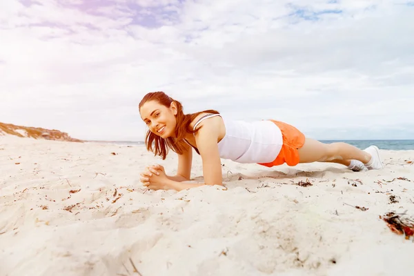 Mujer joven entrenando en la playa afuera —  Fotos de Stock