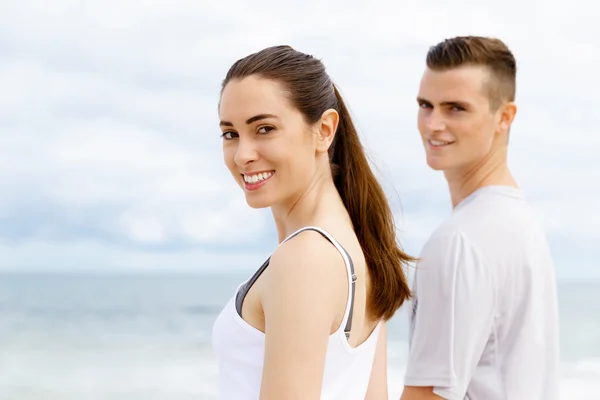 Pareja joven buscando reflexivo mientras están de pie uno al lado del otro en la playa —  Fotos de Stock