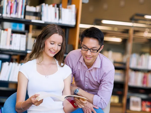 Twee jonge studenten in de bibliotheek — Stockfoto