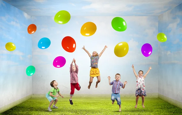 Lekfulla barn fånga ballonger — Stockfoto