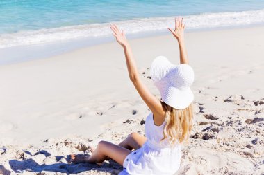 Genç bir kadın sahilde dinleniyor.