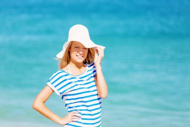 Genç bir kadın sahilde dinleniyor.