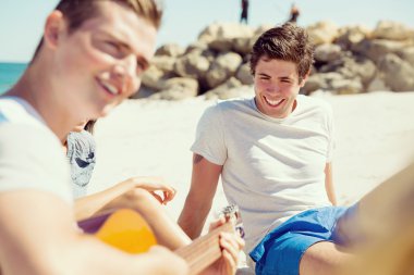 Sahilde gitar ile güzel gençler