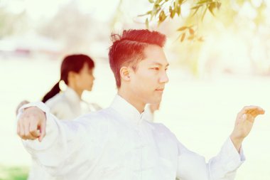 Yakışıklı adam Thai Chi yapıyor.