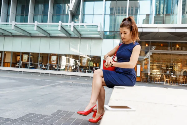 Mujer de negocios en segundo plano con un teléfono inteligente — Foto de Stock