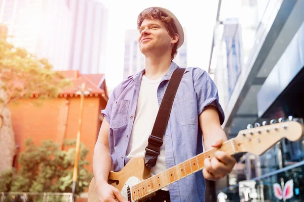 Young musician with guitar in city — Stock Photo, Image