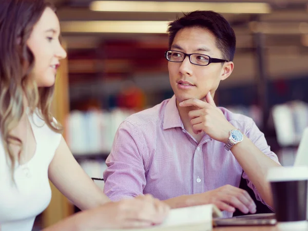 Happy male student working at the library — Stock Photo, Image