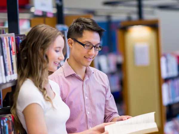 Twee jonge studenten in de bibliotheek — Stockfoto