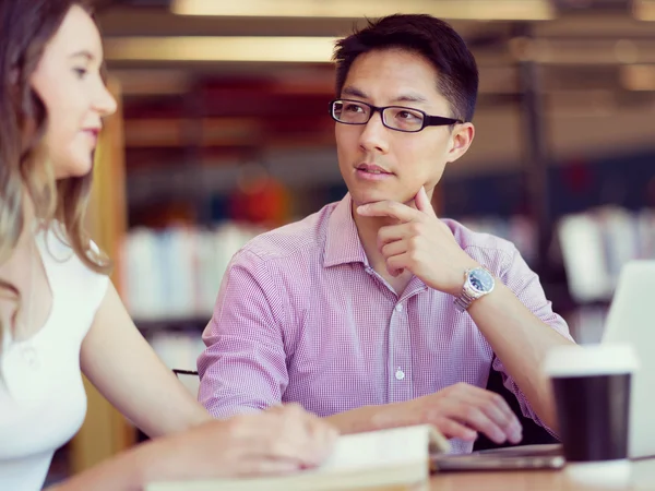 Happy male student working at the library — Stock Photo, Image