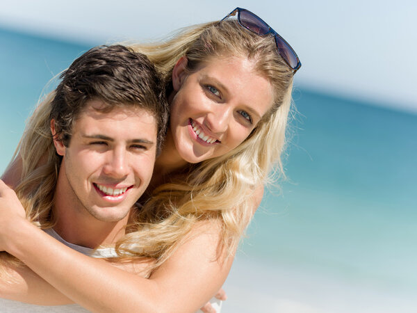 Portrait of man carrying girlfriend on his back