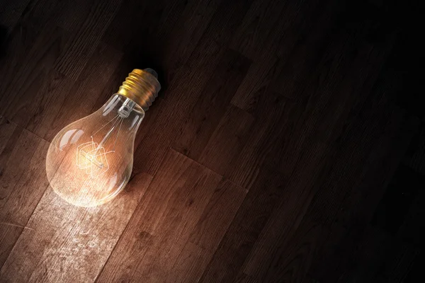 Light bulb op houten oppervlak — Stockfoto