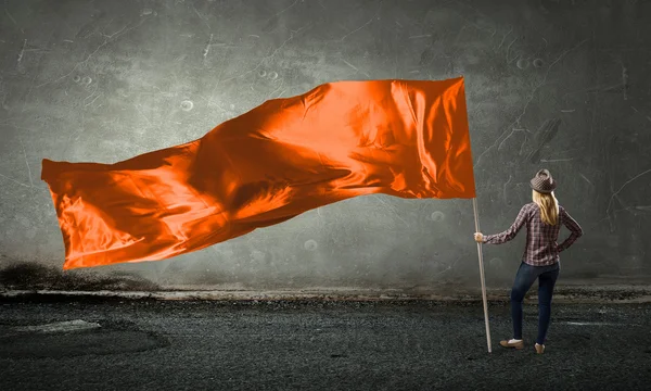 Mujer con bandera naranja ondeando —  Fotos de Stock