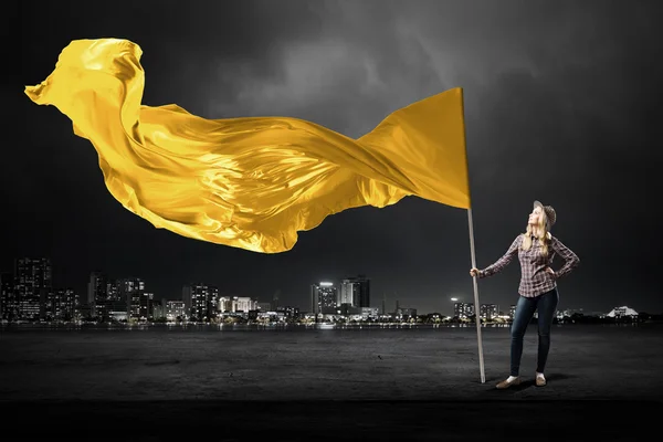 Mujer con bandera amarilla ondeante —  Fotos de Stock