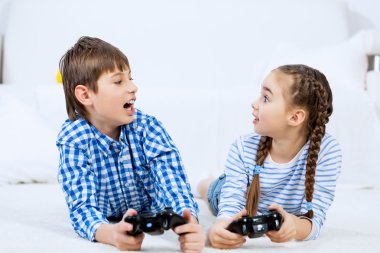 Oyun konsolu oynayan çocuklar