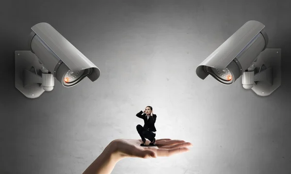 Junge verängstigte Frau im Zimmer unter Kontrolle der Videokamera — Stockbild Kamera behält Frau im Auge — Stockfoto