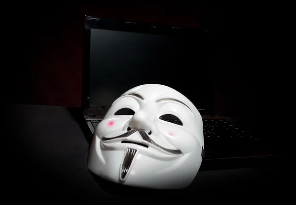 Névtelen maszk sötét át laptop — Stock Fotó
