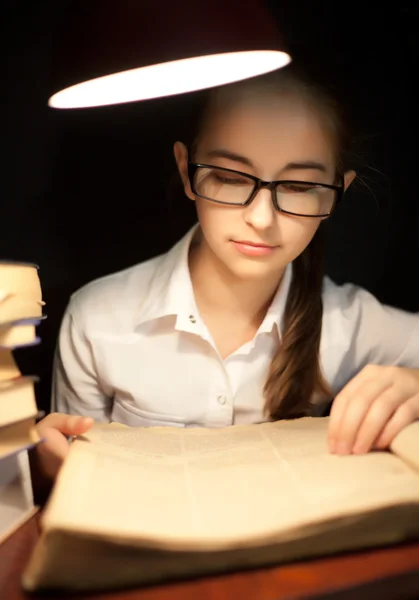 Young girl reading book under lamp — Stock Photo, Image