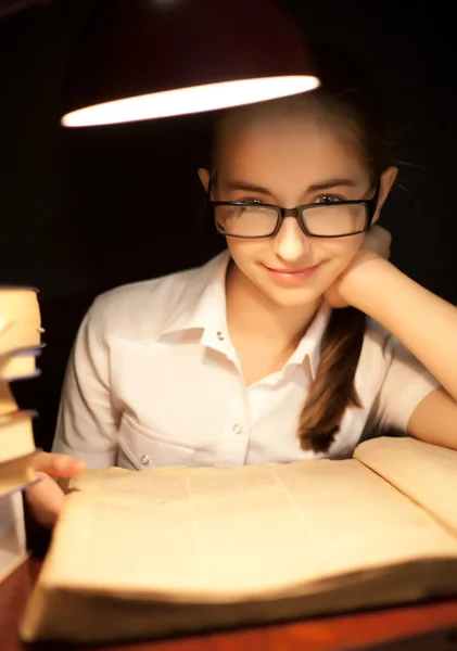 Jovencita leyendo libro bajo lámpara — Foto de Stock
