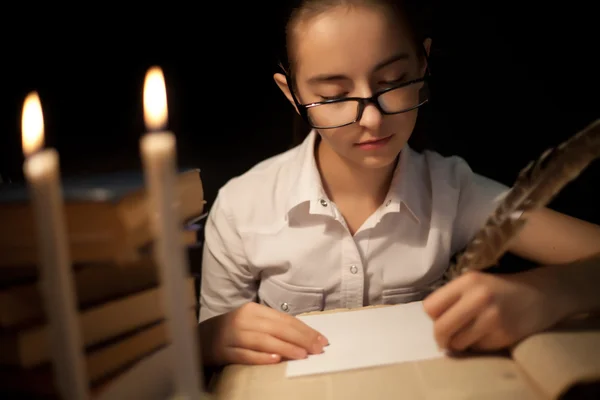 Młoda dziewczyna pisze z piór — Zdjęcie stockowe