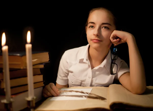 Młoda dziewczyna myśli o książki w bibliotece — Zdjęcie stockowe