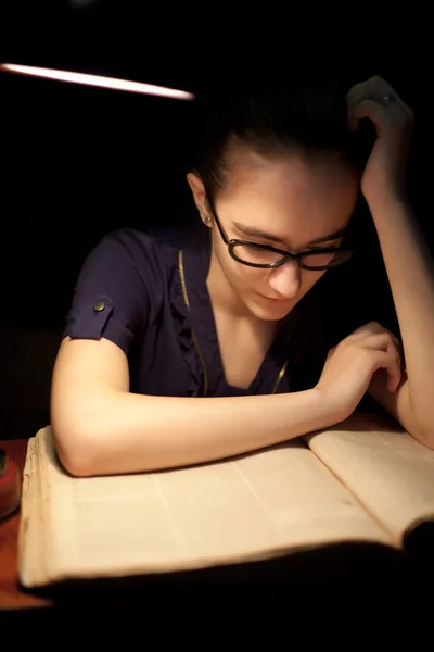 女の子は暗い図書館で本を読んで — ストック写真