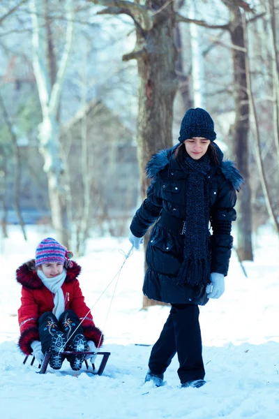 Girls with sledge rest at winter snow — Stock Photo, Image