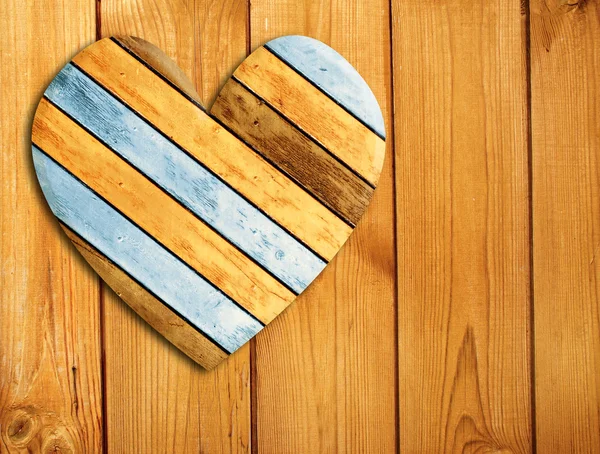 Coração de madeira na parede de madeira velha — Fotografia de Stock