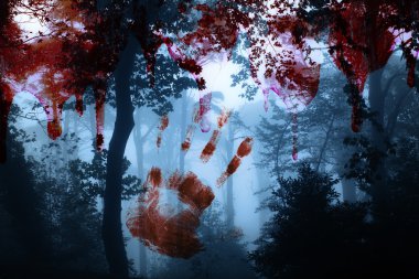 Bloody hand print and blood streaks on the background of the misty forest