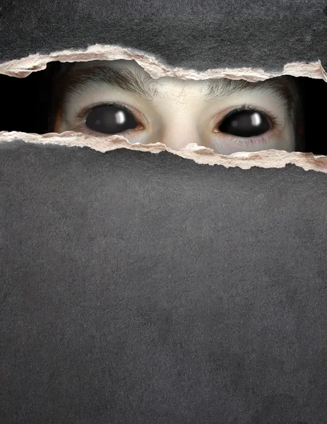 Monster eye in hole in the paper — Stock Photo, Image