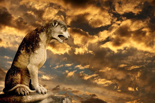 Sunset, ancient lion statue and storm sky — Stock Photo, Image