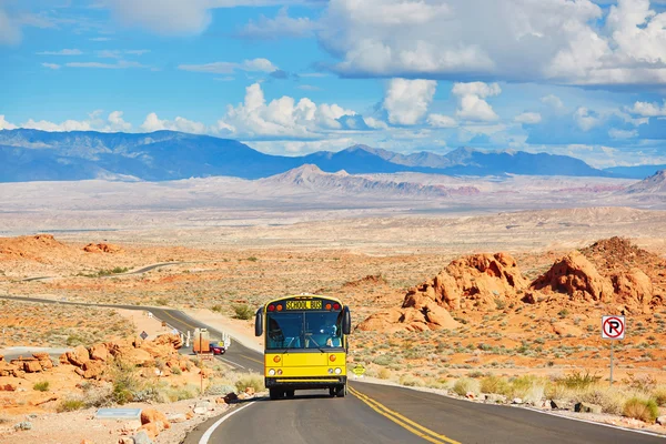 Scuolabus guida su strada tortuosa nel parco nazionale Valle del Fuoco — Foto Stock