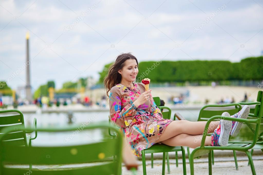Young Parisian woman in the Tuileries garden, eating ice cream