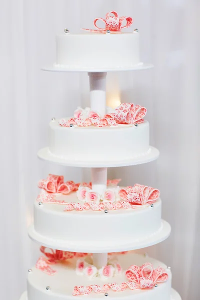 Весільний торт прикрашений рожевими цукровими стрічками — стокове фото