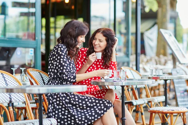 Beautiful twin sisters drinking coffee — Stock Photo, Image