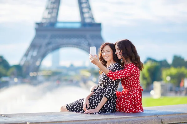 Lindas irmãs gêmeas tirando selfie em frente à Torre Eiffel — Fotografia de Stock